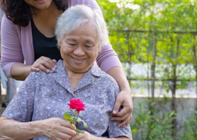Smiling senior woman in wheelchair holding a rose