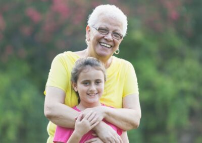Smiling grandmother embracing granddaughter from behind