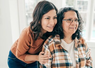 Adult daughter embracing senior mother from behind