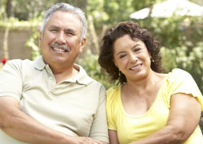 Senior couple smiling while sitting on outdoor bench