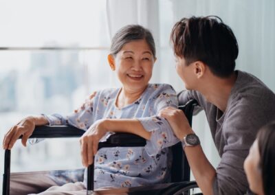Senior woman in wheelchair smiling at adult son