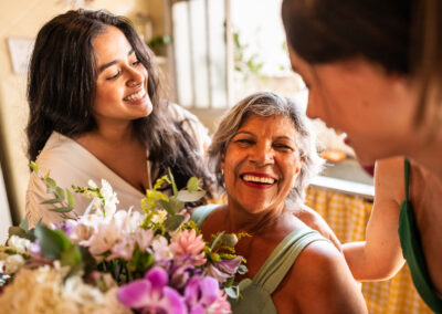 Senior woman receiving flowers from two women